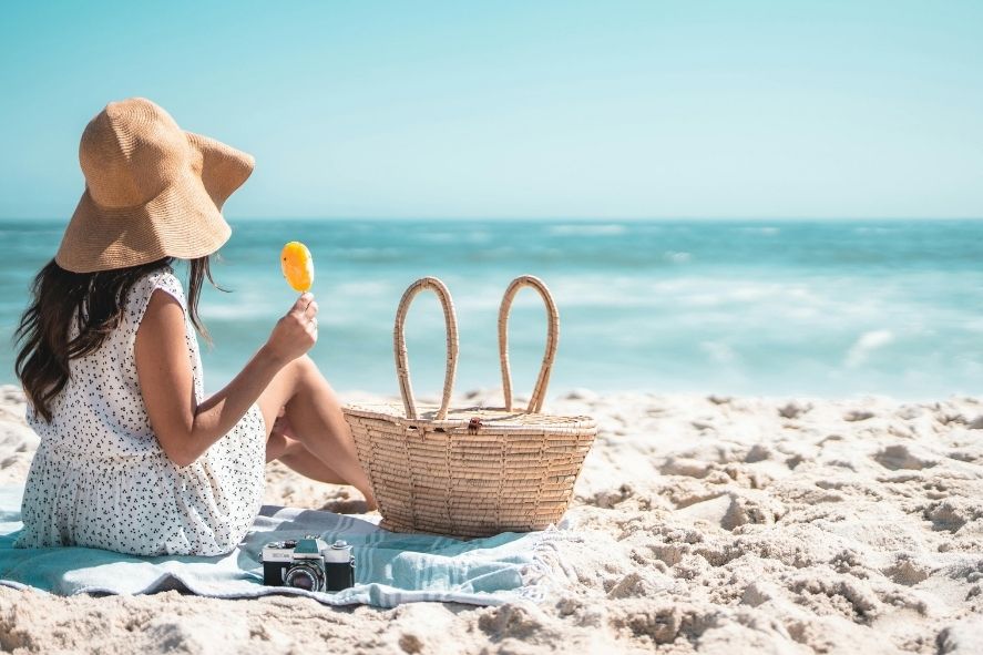 woman relaxing on nai harn beach with a snack